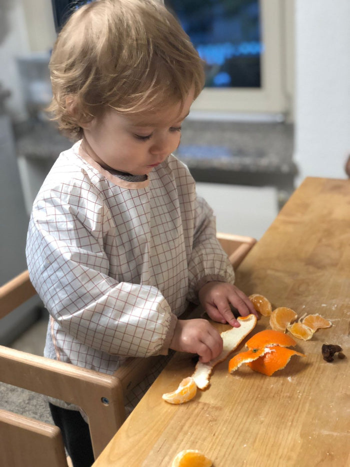 Kind schält eine Orange im Tuki Lernturm
